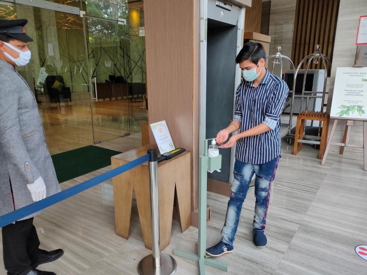 فندق ويلكوم هوتل بنجالور بنغالور المظهر الخارجي الصورة A man uses a hand sanitizer at a hotel in India